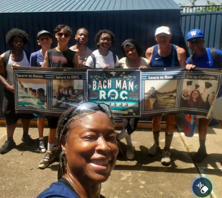 Group holding Bachman ROC banner promoting rowing and education.