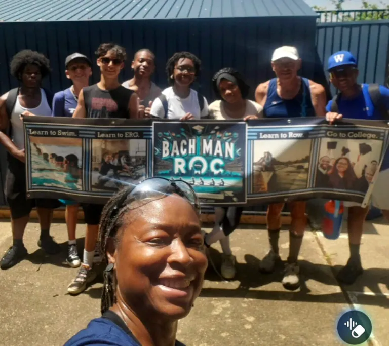 Group holding Bachman ROC banner promoting rowing and education.